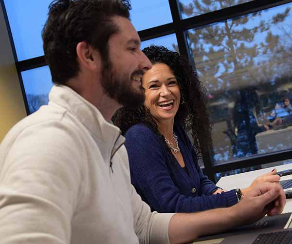 Two people smiling in a meeting.