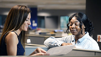 Two women discuss a report.