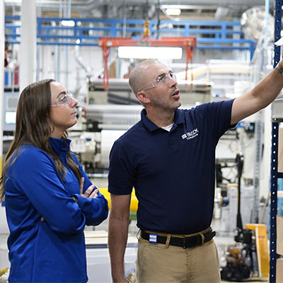 Two workers inspecting a manufacturing area.