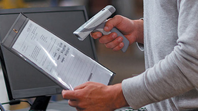 Person scanning a manufacturing document with an RFID scanner